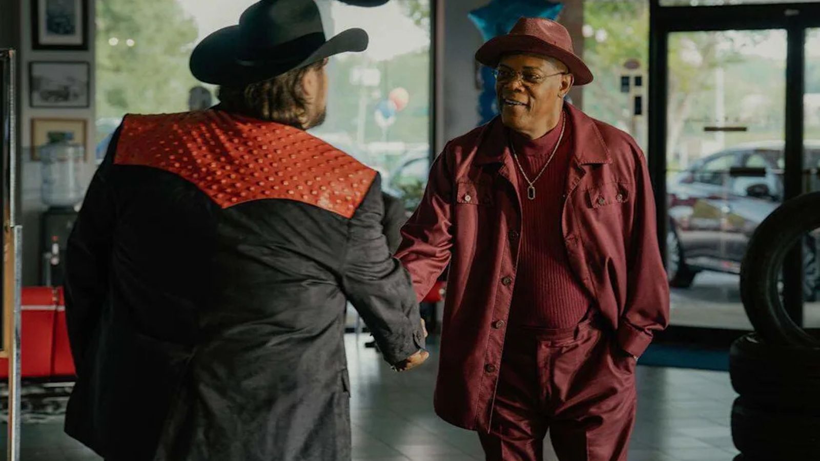 Samuel L. Jackson bordó öltönyben és kalapban egy autókereskedésben a Frisco King forgatásán