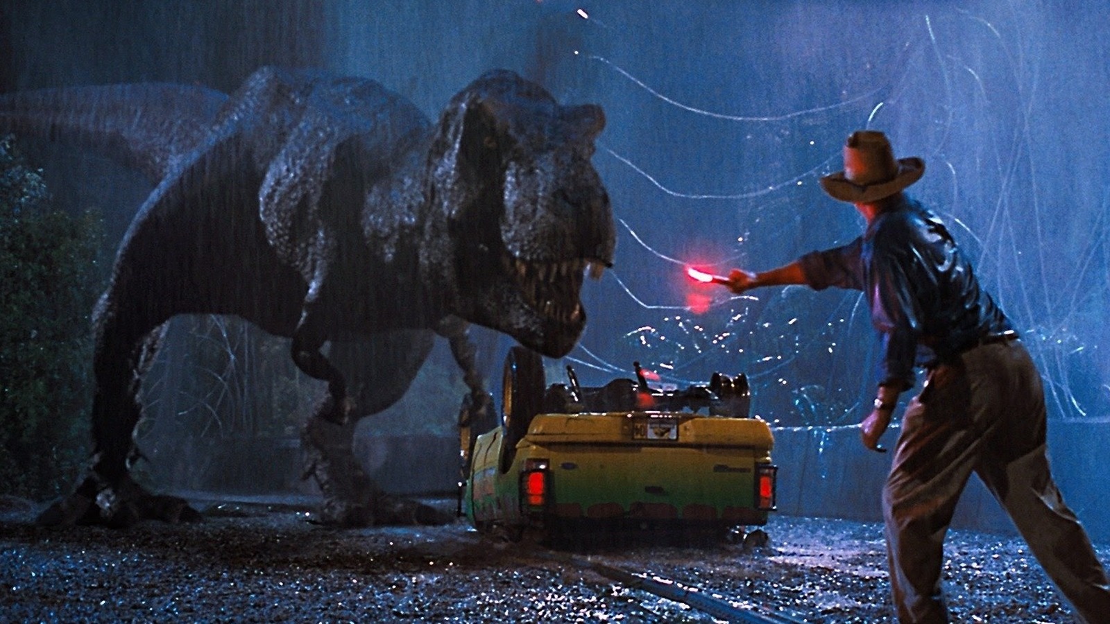 Alan Grant a Tyrannosaurus előtt fáklyával a Jurassic Park című filmben