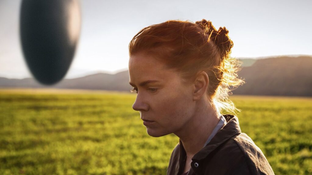 Az Érkezés megmutatta, miért veszélyesebb egy félreértés az idegenek fegyvereinél Amy Adams Louise Banks szerepében napfényes mezőn az Érkezés című sci-fiben
