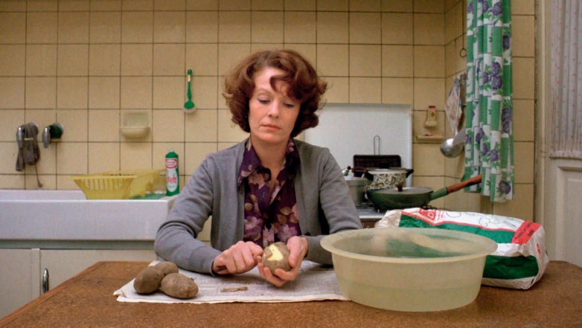 Delphine Seyrig Jeanne Dielman szerepében krumplit hámoz a konyhában Chantal Akerman 1975-ös filmjében.