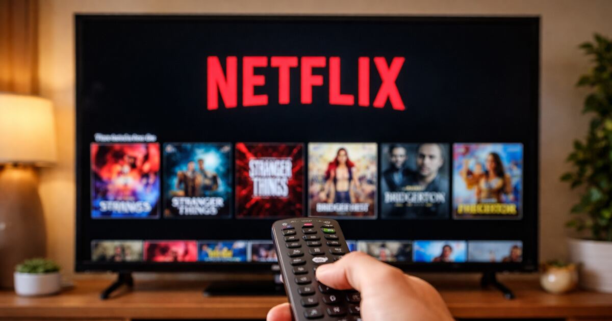 Távirányítót tartó néző a Netflix kínálatát böngészi egy televízión